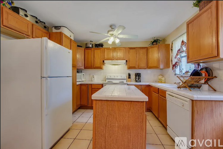A kitchen with wooden cabinets and a white refrigerator.