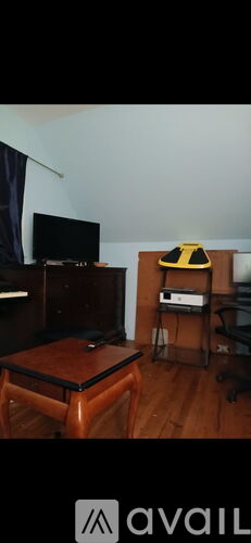 A living room with a television, a chair, and a coffee table.