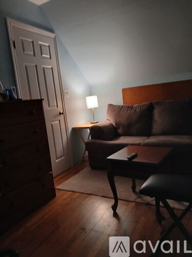 A living room with a brown couch and a wooden floor.