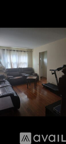 A living room with a black couch and a television.