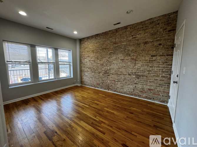 A room with wooden floors and a brick wall.