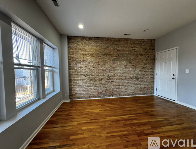 A room with wooden floors and a brick wall.