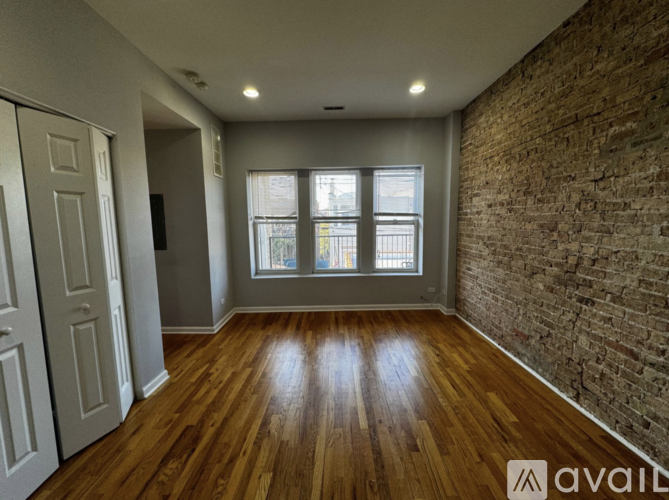 A room with wooden floors and a brick wall.
