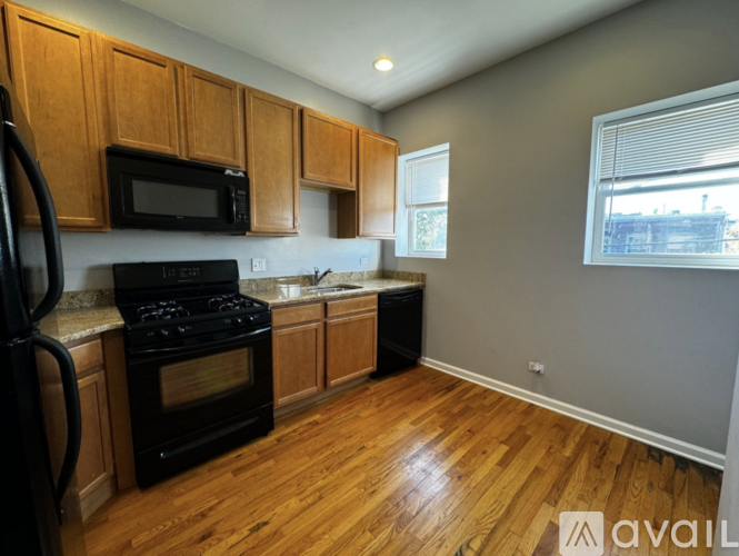 A kitchen with wooden cabinets and black appliances.