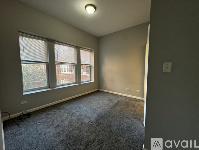 A room with a carpeted floor and a window overlooking a building.