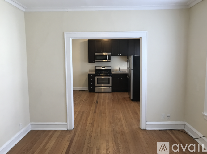 A kitchen with wooden floors and white walls is available for rent.