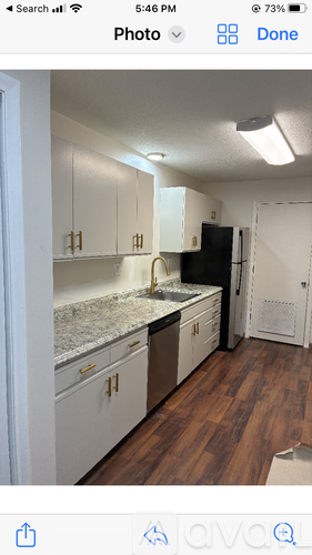 A kitchen with white cabinets and a granite countertop.