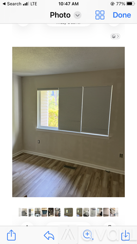 A room with a window covered by blinds.