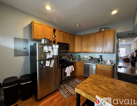 A kitchen with wooden cabinets and a stainless steel refrigerator.