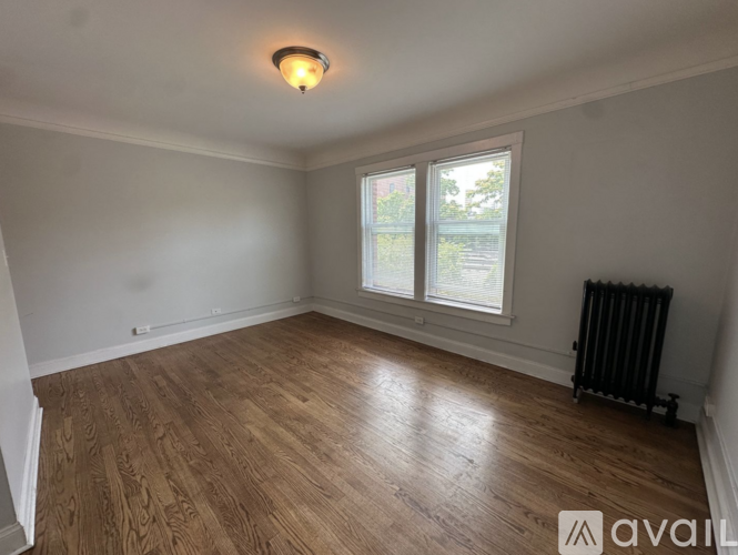 A room with wooden flooring and a window.