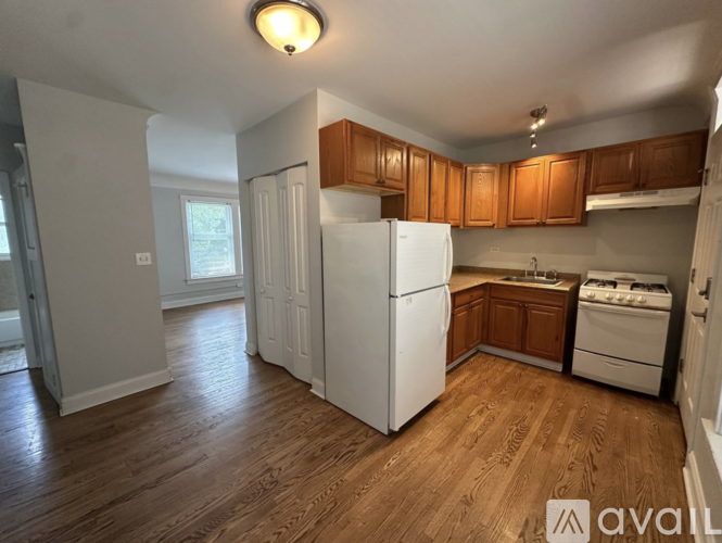 A kitchen with white appliances and wooden cabinets.