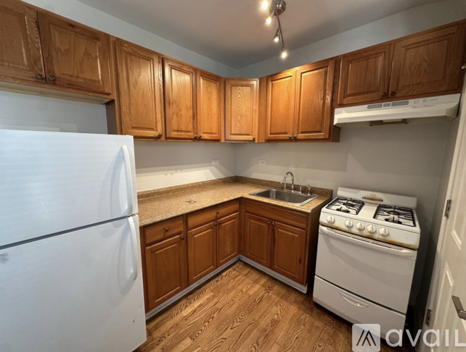 A kitchen with wooden cabinets and a white refrigerator.
