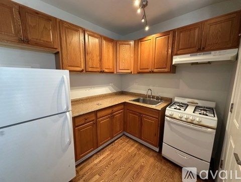 A kitchen with wooden cabinets and a white refrigerator.