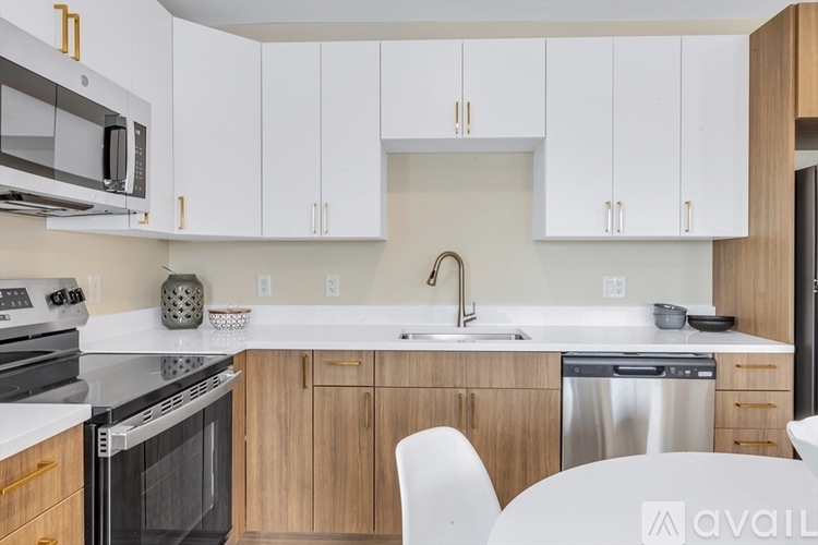 A kitchen with white cabinets and a stainless steel dishwasher.