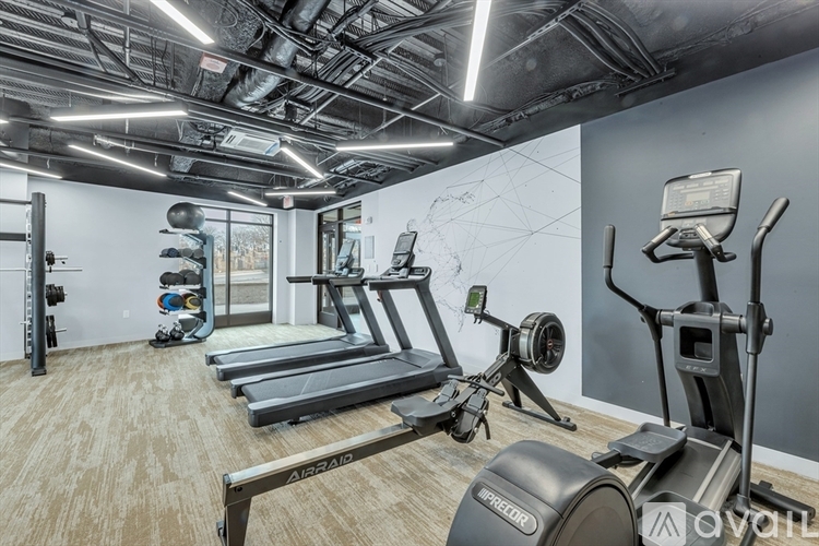 A gym with treadmills, elliptical machines, and other exercise equipment.