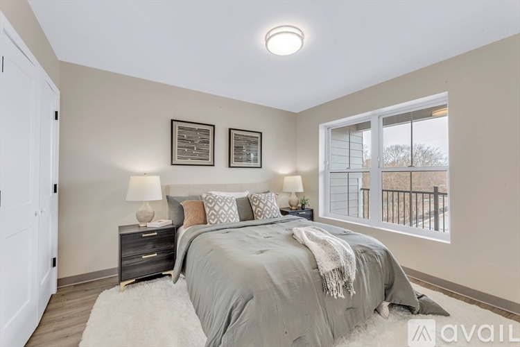 A bedroom with a large bed and a window overlooking a balcony.