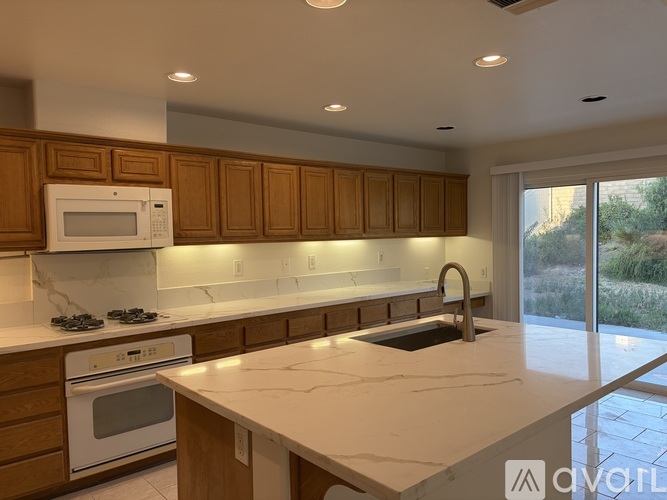 A kitchen with brown cabinets and white appliances.