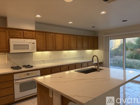 A kitchen with brown cabinets and white appliances.