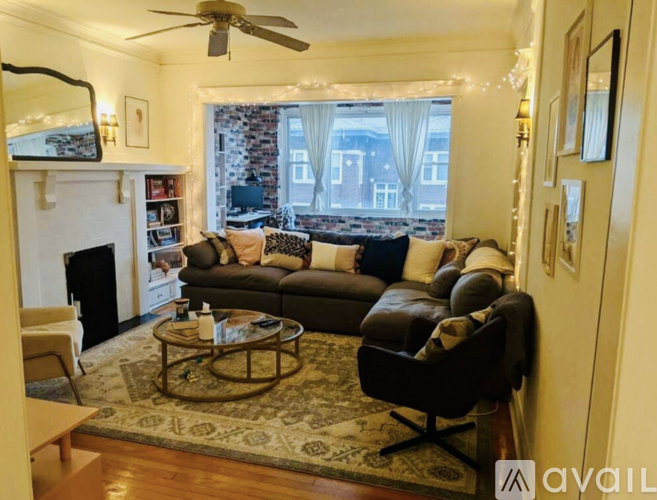 A living room with a fireplace and a large window.