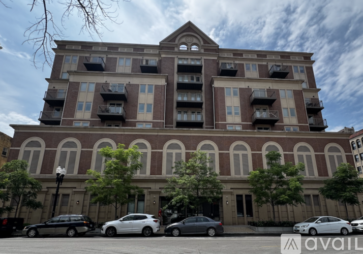A large apartment building with cars parked in front.