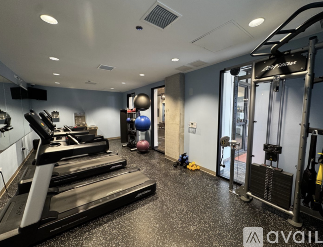 A gym with treadmills, weights, and exercise equipment.