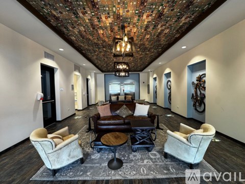 A living room with a brown leather couch and a chandelier.