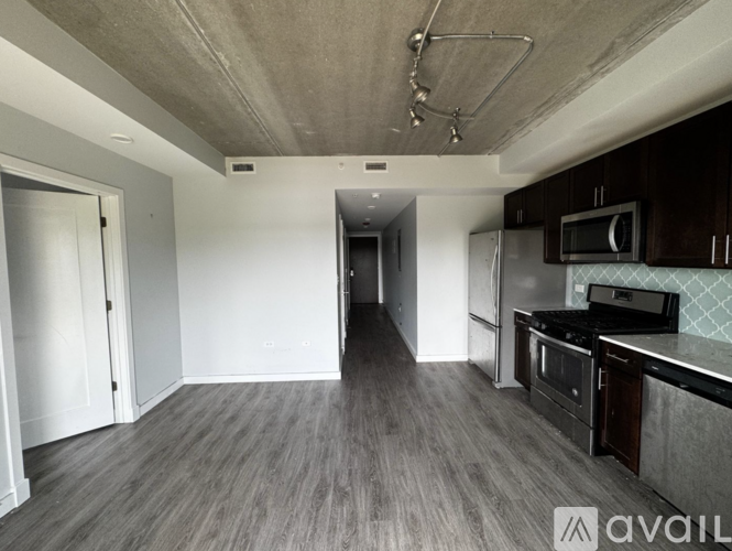 A kitchen with dark wood cabinets and a stainless steel refrigerator.