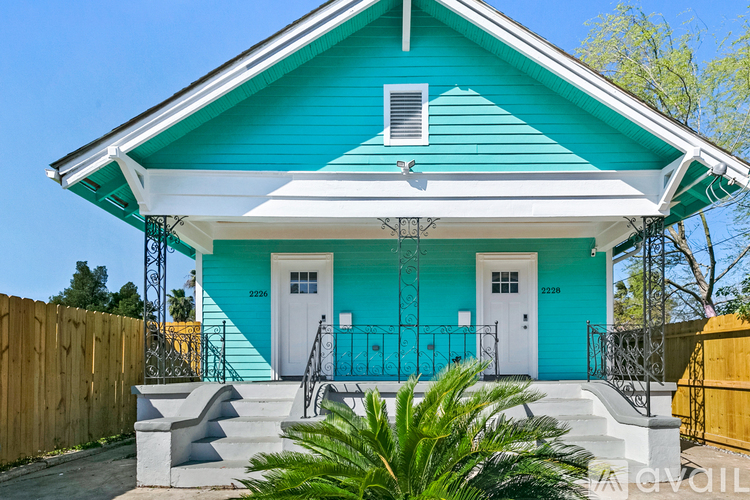 A blue house with a white door and a white window.