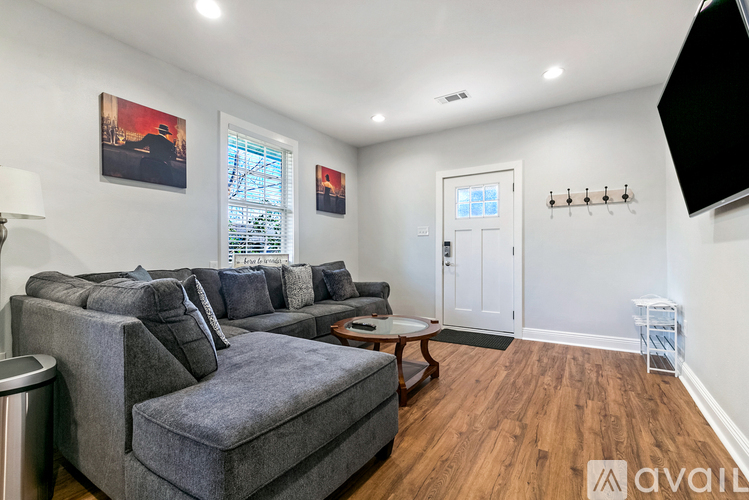 A living room with a grey couch and a wooden floor.