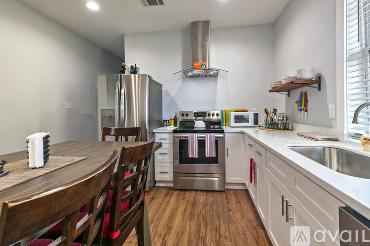 A kitchen with wooden chairs and stainless steel appliances.