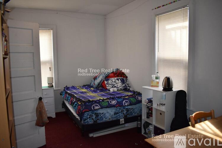 A bedroom with a bed, nightstand, and chair.