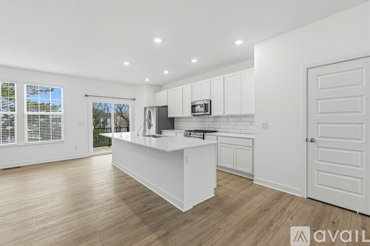 A kitchen with white cabinets and a wooden floor.