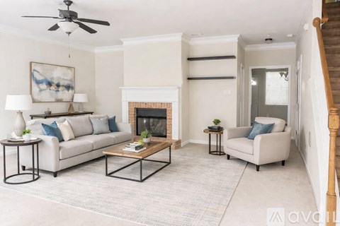 A living room with a fireplace, a sofa, a chair, and a painting on the wall.