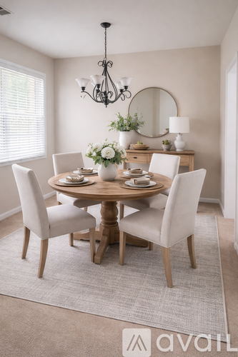 A dining room with a round table and chairs.