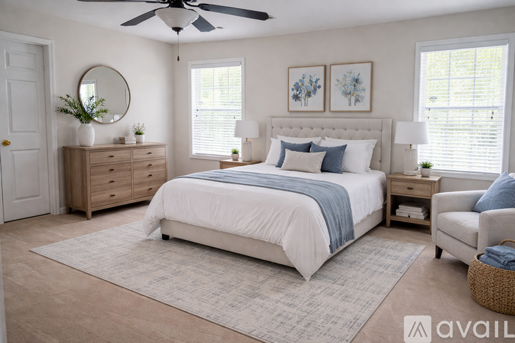 A bedroom with a large bed, a dresser, a mirror, and a ceiling fan.