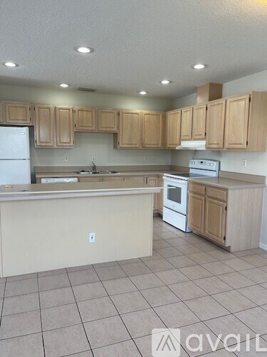 A kitchen with wooden cabinets and a white refrigerator.
