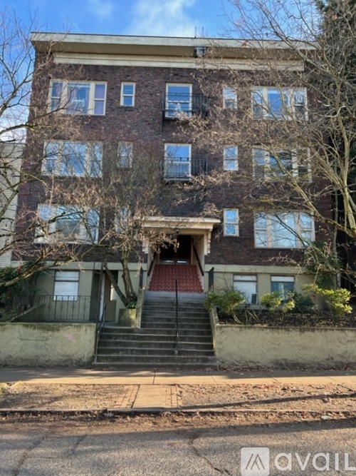 A brick building with a staircase leading to the entrance.
