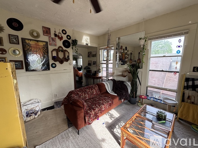 A living room with a couch, a coffee table, and a yellow refrigerator.