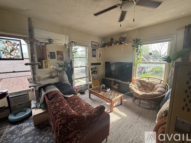 A living room with a couch, chair, and television.