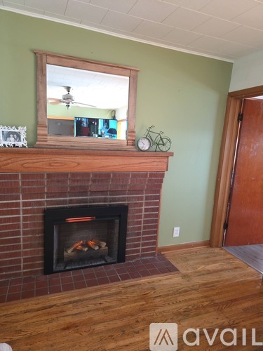 A fireplace with a mirror above it and a clock on the mantle.