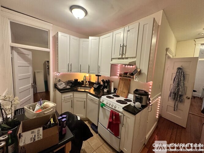 A kitchen with white cabinets and a black stove top.