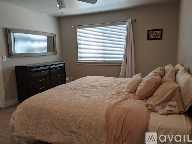 A bedroom with a bed, dresser, and window.
