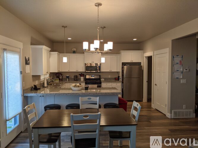 A kitchen with a table and chairs in front of it.