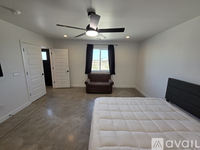 A bedroom with a large bed and a ceiling fan.