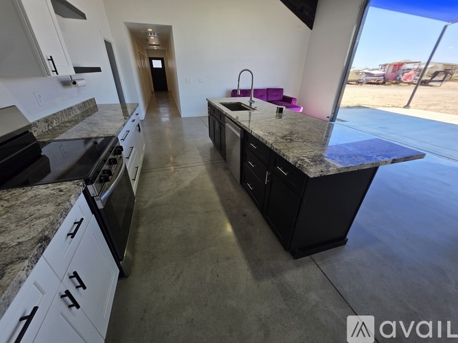 A kitchen with granite countertops and white cabinets is available for rent.
