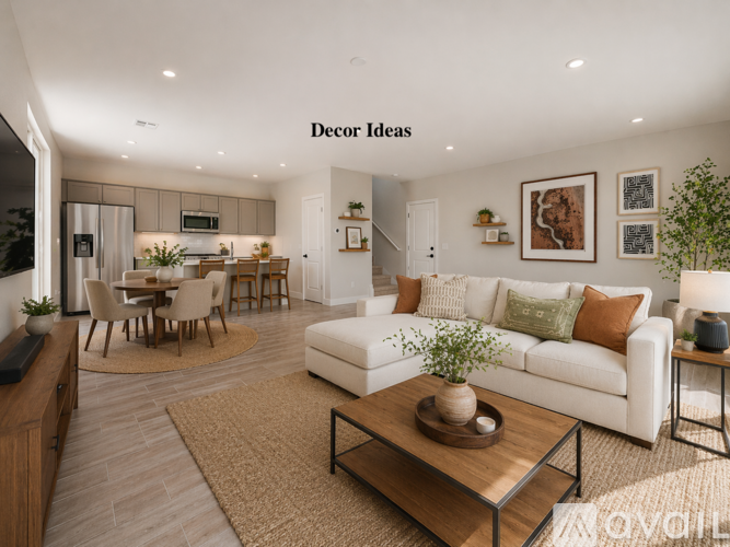 A modern living room with a dining area and a kitchen in the background.