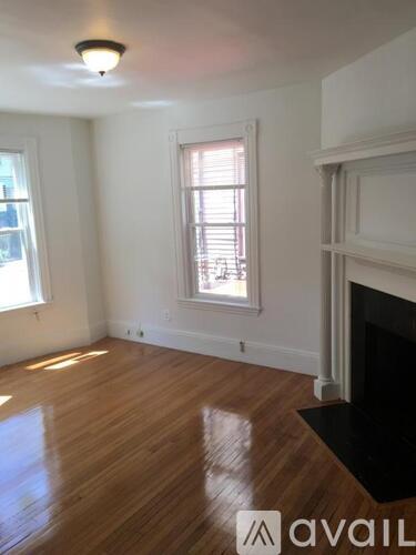 A room with wooden floors and a fireplace.