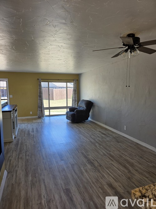 A room with a ceiling fan and a chair.