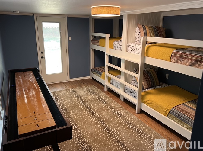 A room with bunk beds and a wooden bench.