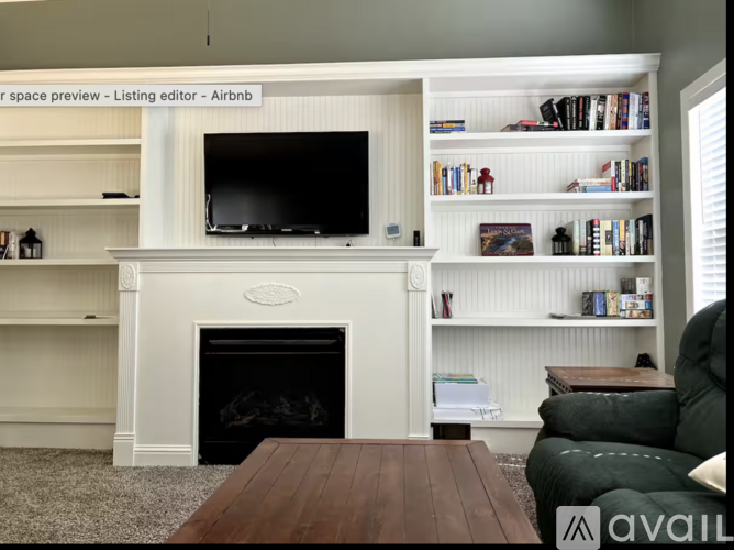 A living room with a fireplace and a television on the wall.